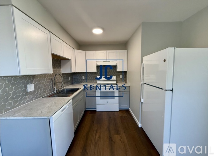 A kitchen with a white fridge and cabinets with a sign that says "RENTALS".