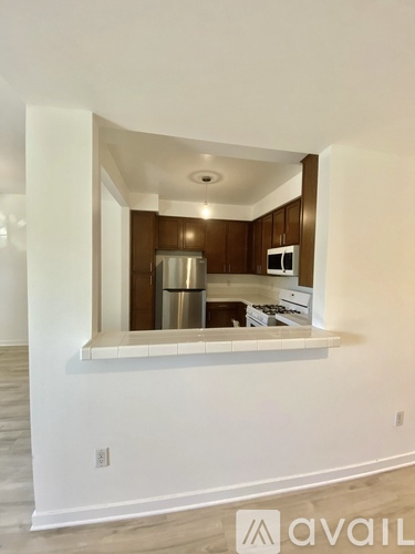 A kitchen with a white countertop and brown cabinets.