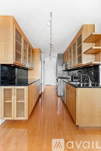 A kitchen with wooden cabinets and a black countertop.