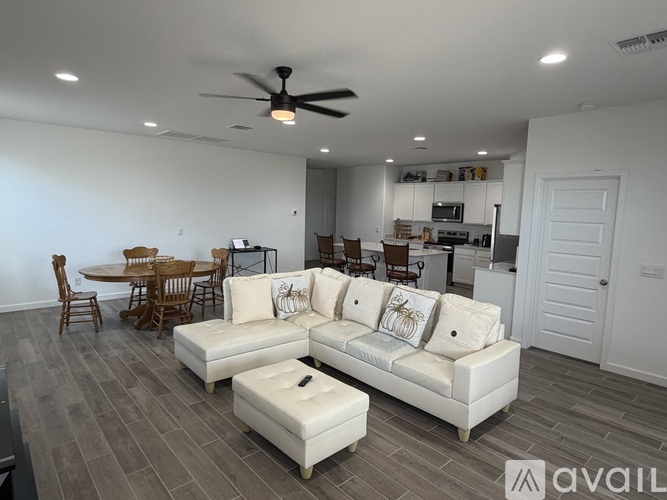 A living room with a white couch and a ceiling fan.