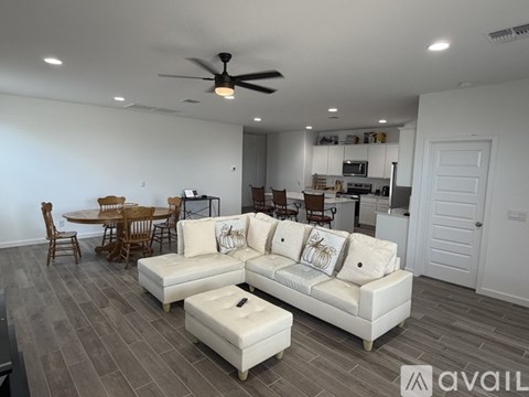 A living room with a white couch and a ceiling fan.