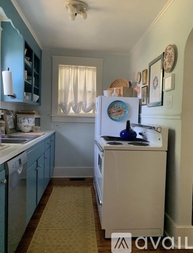 A kitchen with a white fridge and a washing machine.