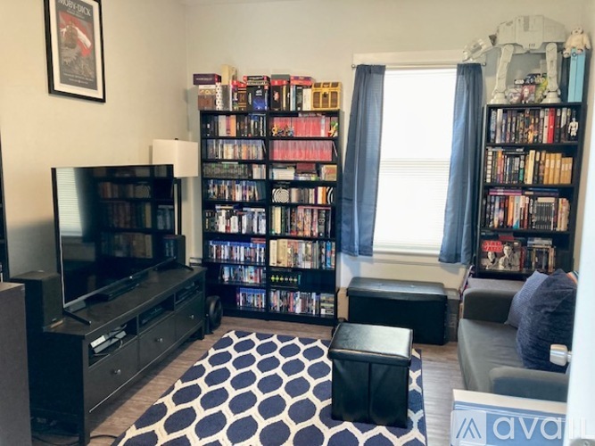 A living room with a television, a bookshelf, and a couch.
