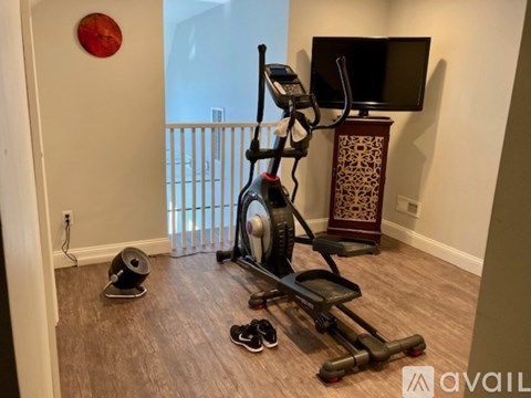 A home gym with a treadmill, elliptical trainer, and weights.