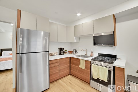 A modern kitchen with a stainless steel refrigerator and oven.