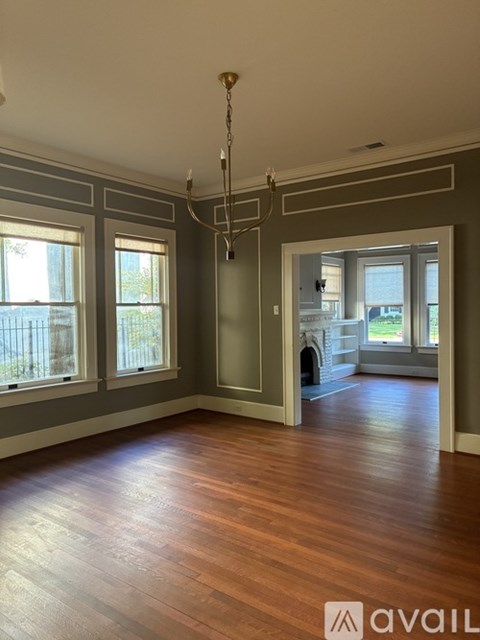 A room with wooden floors and a chandelier.