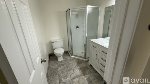 A bathroom with a toilet, sink, and shower.