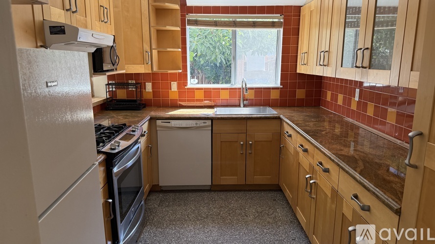 A kitchen with wooden cabinets and a granite countertop.