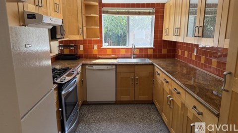 A kitchen with wooden cabinets and a granite countertop.