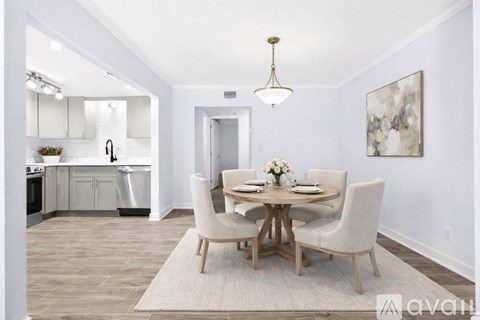 A dining room with a round table and chairs.