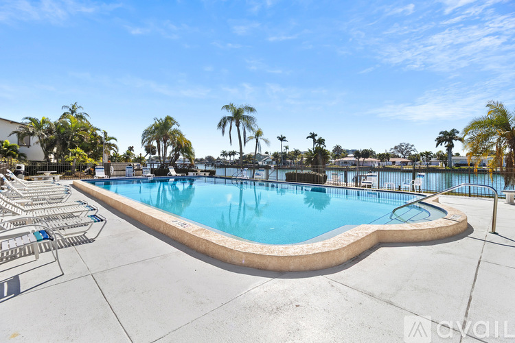 A large outdoor swimming pool surrounded by palm trees.