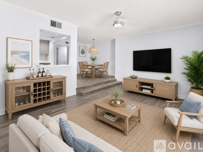 A living room with a beige sofa, wooden coffee table, and a flat-screen TV mounted on the wall.