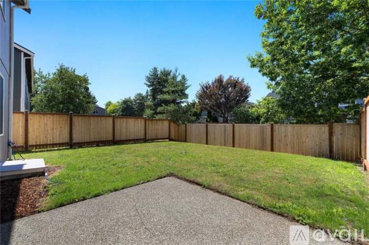 A backyard with a wooden fence and a gravel path.