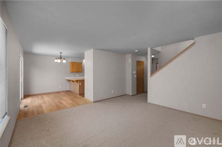 A spacious room with a staircase on the right side.