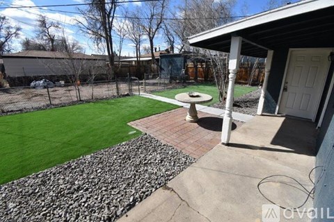 A backyard with a stone pathway leading to a patio.