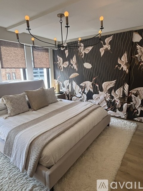A bedroom with a large bed and a chandelier.