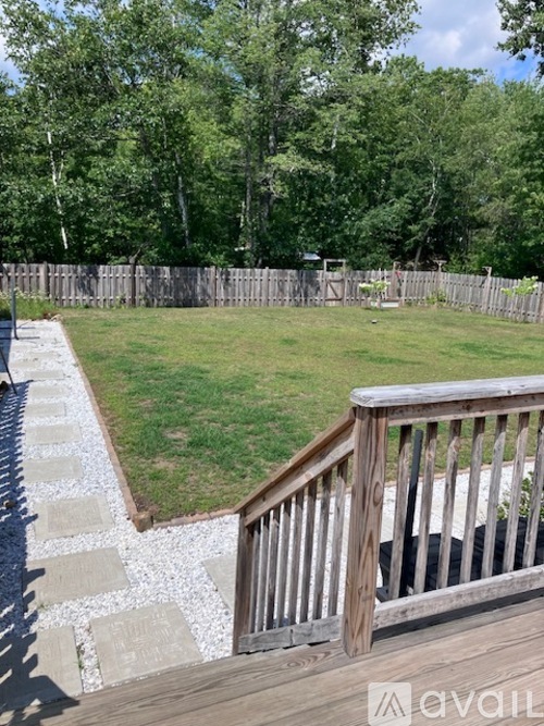A backyard with a wooden deck and a grassy area.