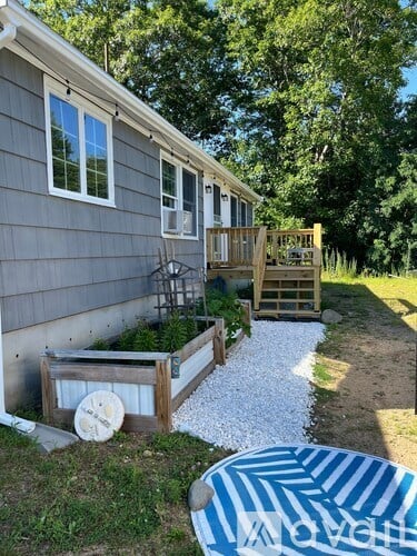 A house with a grey siding and a deck with a railing.