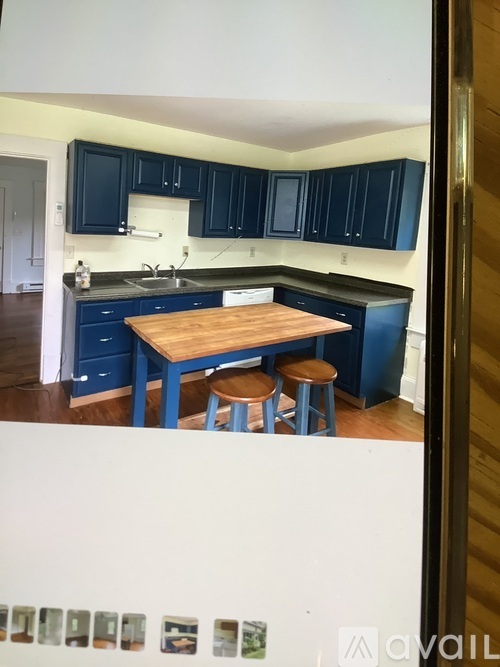 A kitchen with blue cabinets and a wooden island.