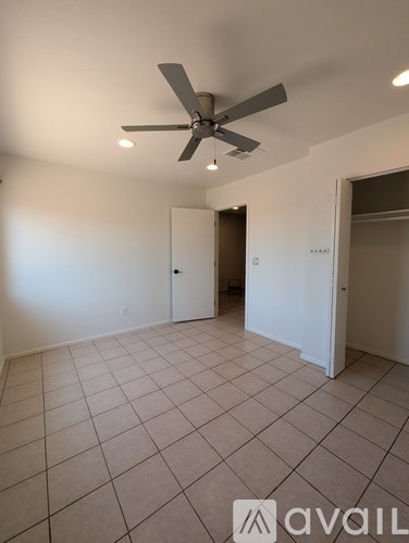 A room with a ceiling fan and tile flooring.