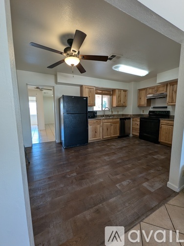A kitchen with a fan on the ceiling and wooden cabinets.