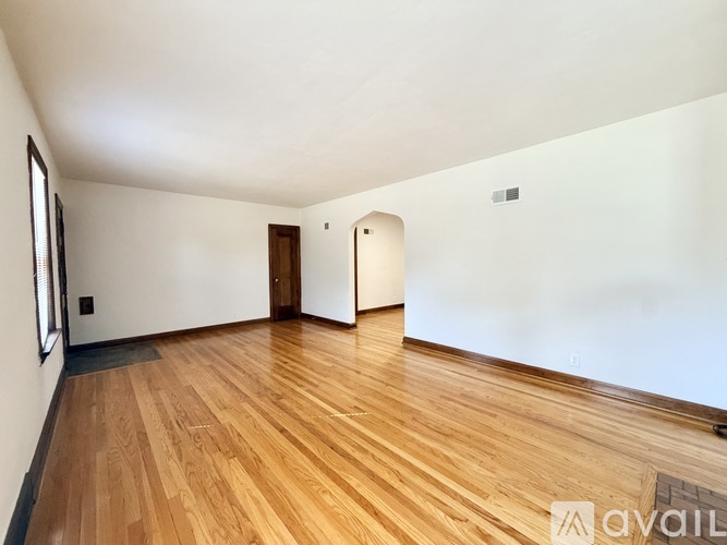 A room with wooden flooring and white walls.