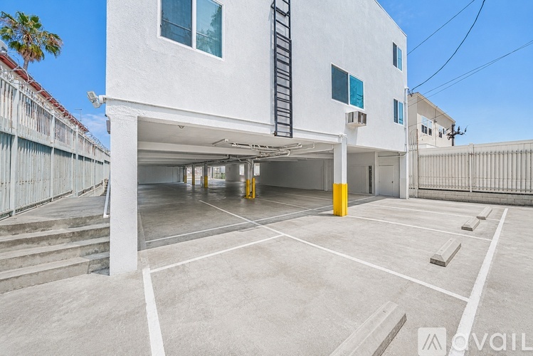 A white building with a garage underneath it.