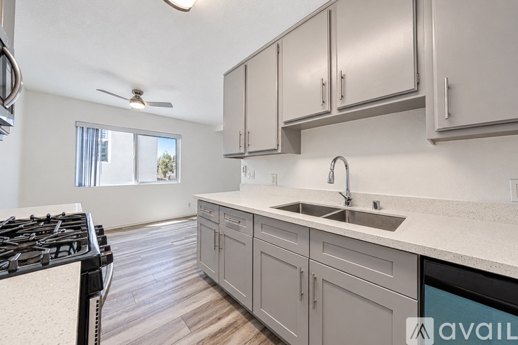 A kitchen with a stove top oven and a sink.