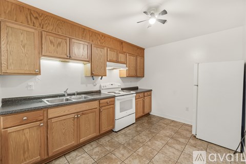 A kitchen with wooden cabinets and a white refrigerator.