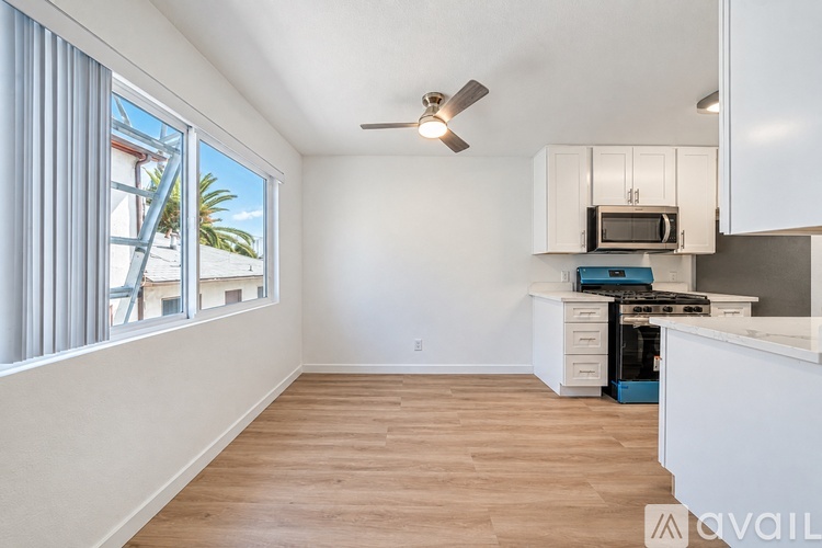 A kitchen with white cabinets and a blue fridge is shown.