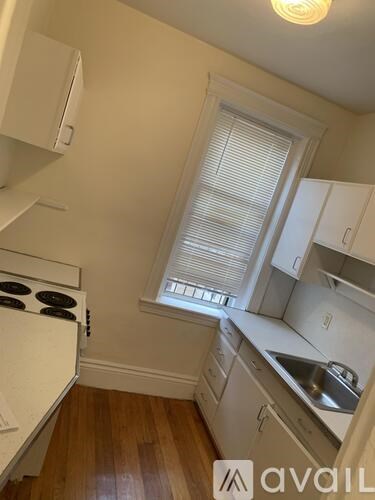 A kitchen with white appliances and wooden floors.