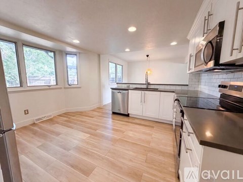 A kitchen with white cabinets and a black countertop.