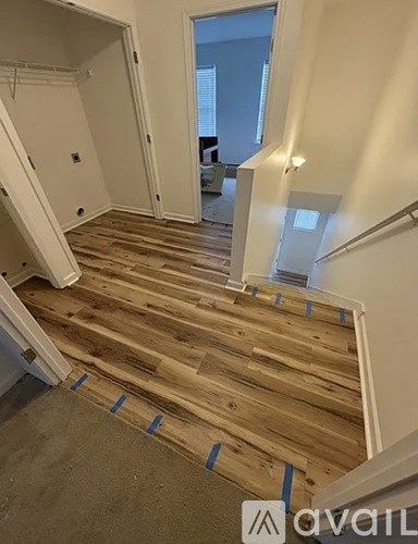 A wooden staircase with a white railing and a window in the background.