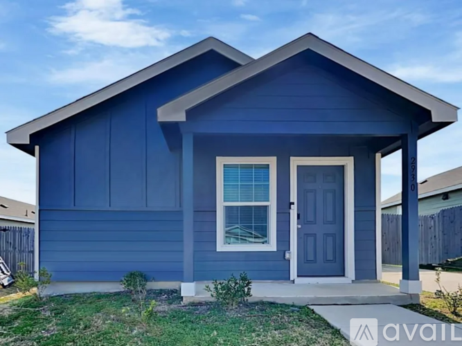 A blue house with a white door and windows.
