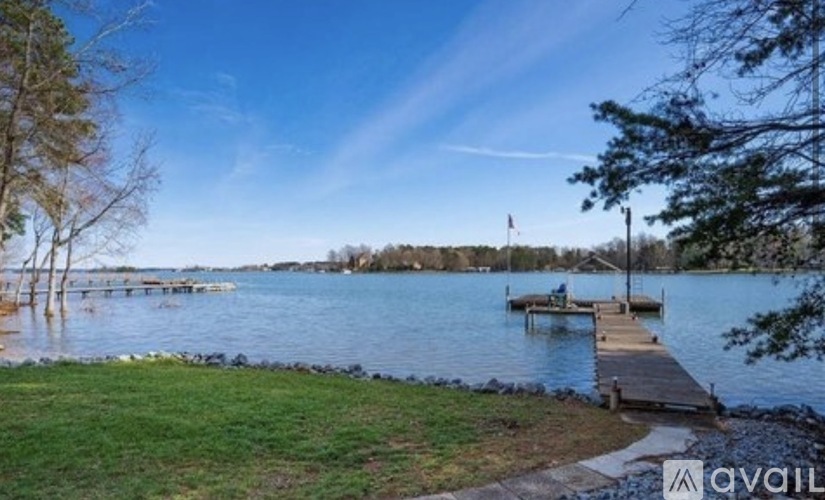 A serene lake with a dock and a flag on the far side.