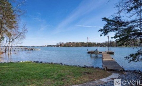 A serene lake with a dock and a flag on the far side.