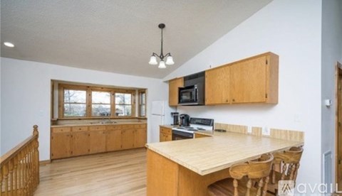 A kitchen with wooden cabinets and a large island.