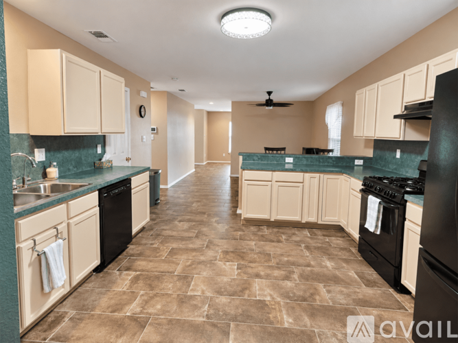 A kitchen with a tile floor and a ceiling fan.