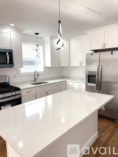A kitchen with a white counter top and stainless steel appliances.