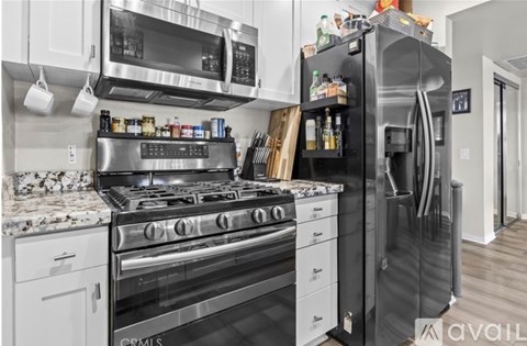 A kitchen with a black refrigerator and stove.