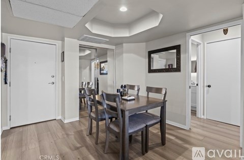 A dining room with a wooden table and chairs.
