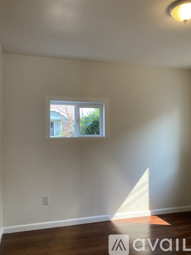 A room with a window and wooden floors.