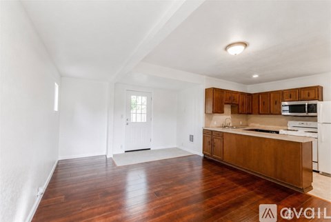 A kitchen with wooden floors and white walls.
