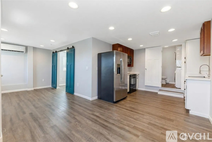 A kitchen area with a refrigerator, oven, and cabinets.