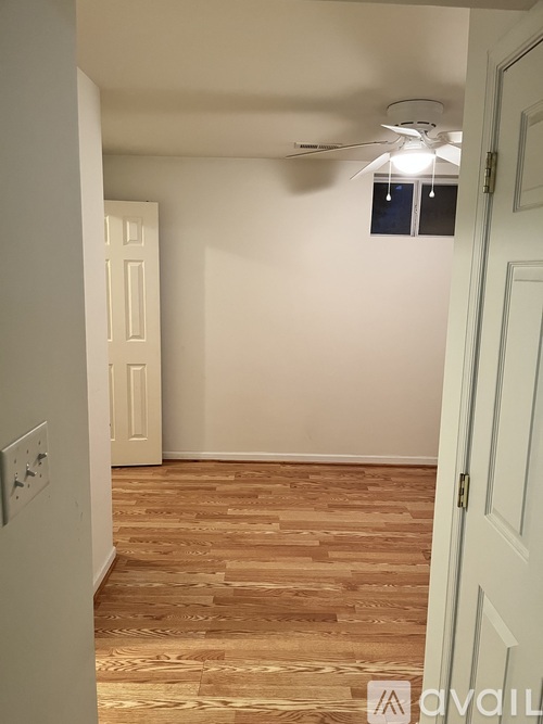 A room with a wooden floor and a ceiling fan.