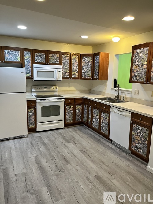 A kitchen with a white refrigerator, microwave, and dishwasher.