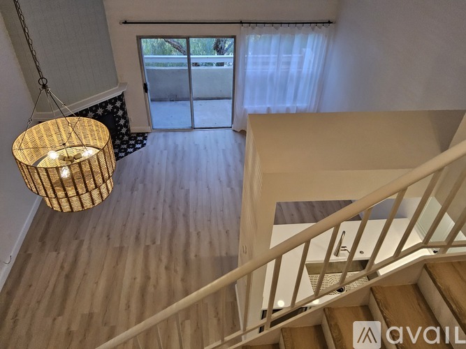 A wooden staircase with a metal railing and a hanging light fixture.