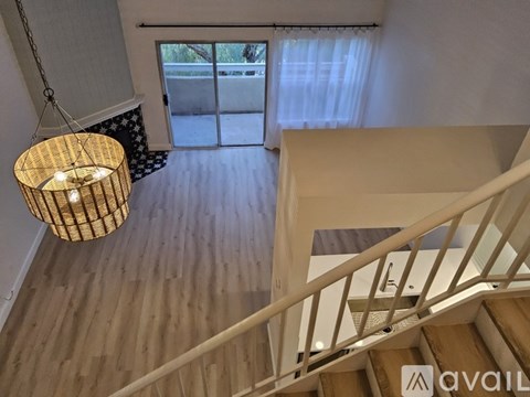 A wooden staircase with a metal railing and a hanging light fixture.