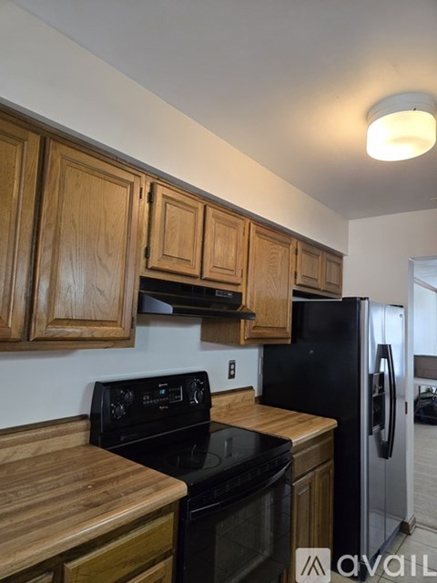 A kitchen with wooden cabinets and black appliances.