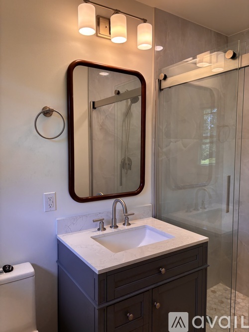A bathroom with a sink, mirror, and toilet.